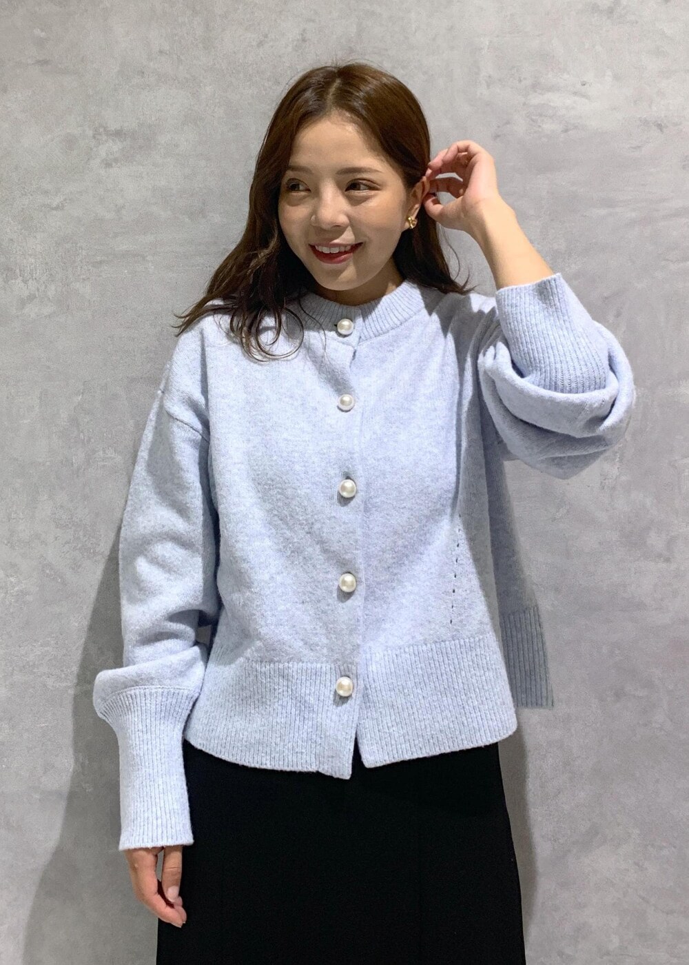 ブラック系のブーツ、ブラック系のショルダーバッグ、ブラック系のスカートを着用したレディースの秋コーディネートの5枚目の写真