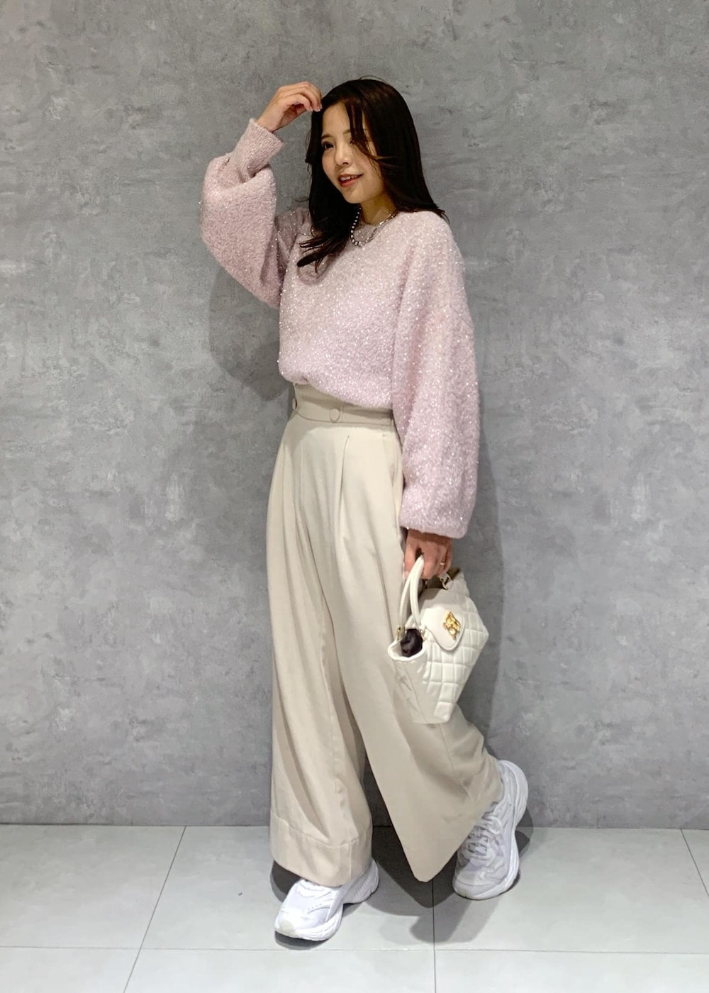 ピンク系のニット/セーター、ベージュ系のその他パンツ、ホワイト系のショルダーバッグを着用したレディースの冬コーディネートの3枚目の写真