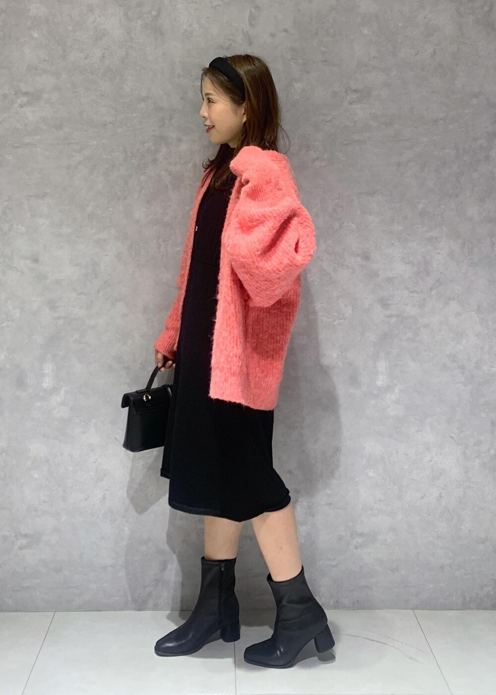 その他のショルダーバッグ、ブラック系のブーツ、ブラック系のワンピースを着用したレディースの秋コーディネートの3枚目の写真