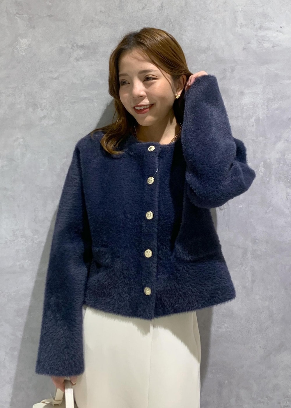 ブルー系のカーディガン/ボレロ、ホワイト系のハンドバッグ、ブラック系のパンプスを着用したレディースの秋コーディネートの7枚目の写真