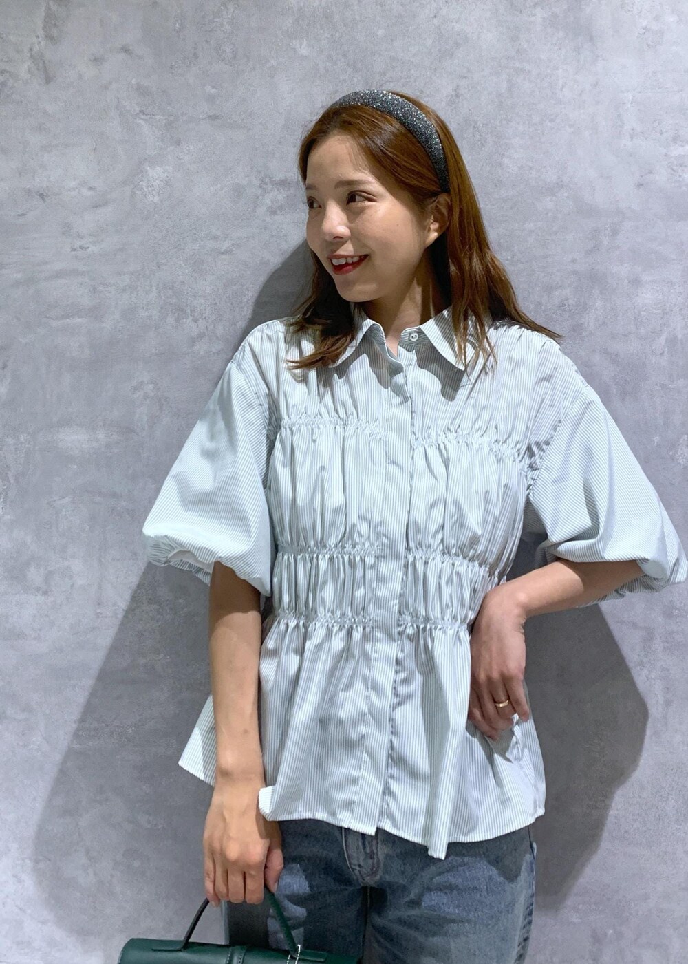 グリーン系のショルダーバッグ、ブルー系のデニムパンツ、グリーン系のシャツ/ブラウスを着用したレディースの夏コーディネートの6枚目の写真