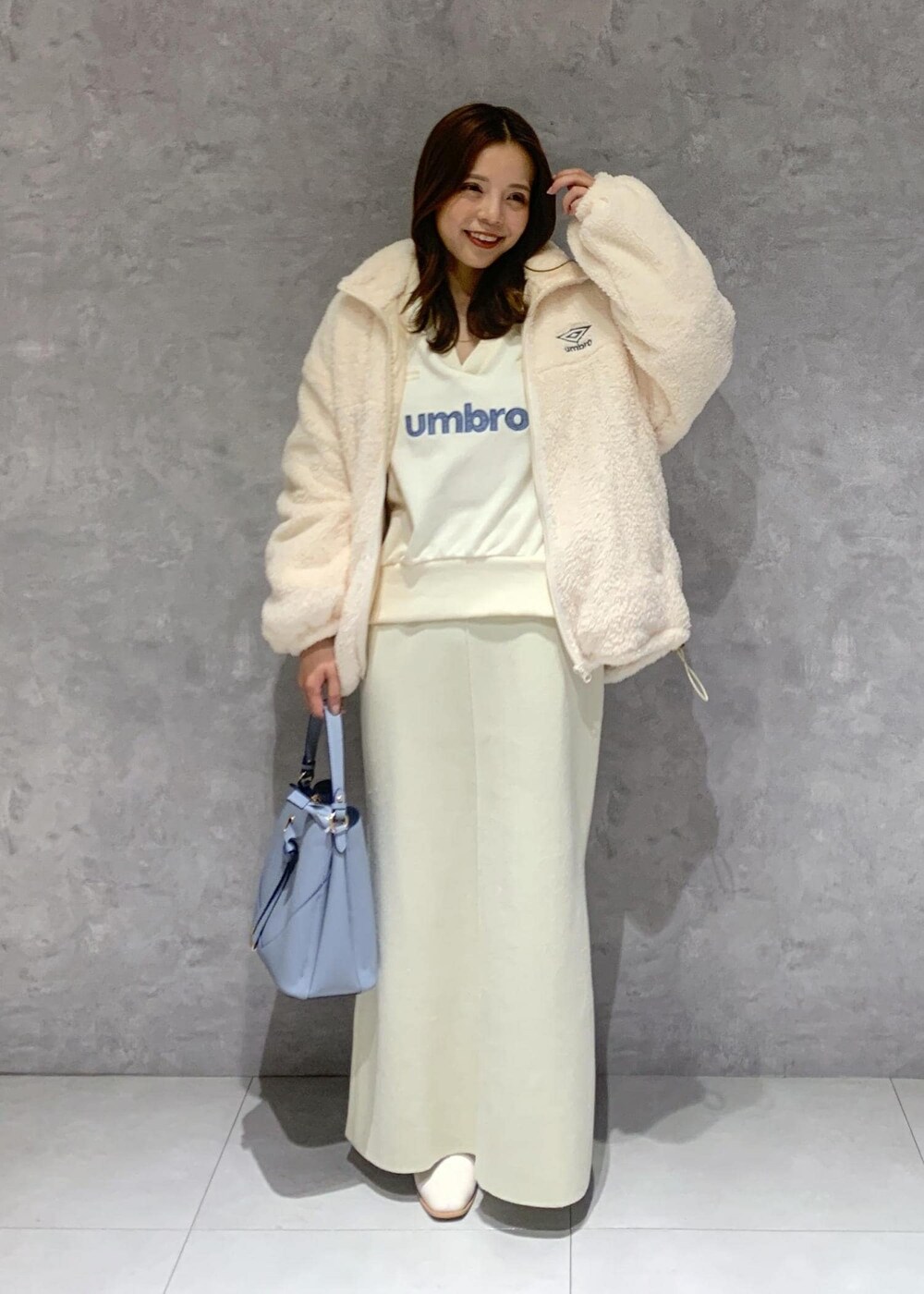 ホワイト系のブーツ、ホワイト系のスカート、ホワイト系のブルゾンを着用したレディースの秋コーディネートの2枚目の写真