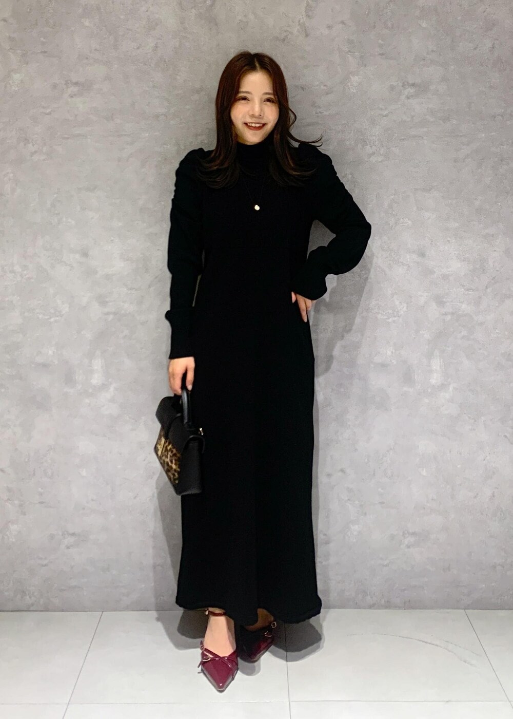 その他のショルダーバッグ、グレー系のステンカラーコート、ブラック系のワンピースを着用したレディースの秋コーディネートの8枚目の写真