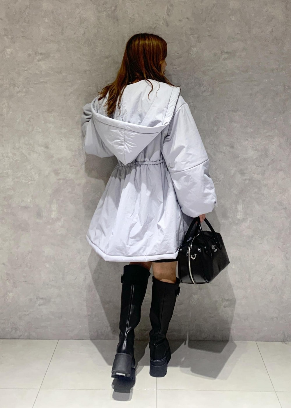 ブラック系のブーツ、ブラック系のスカート、ブルー系のその他アウターを着用したレディースの秋コーディネートの4枚目の写真