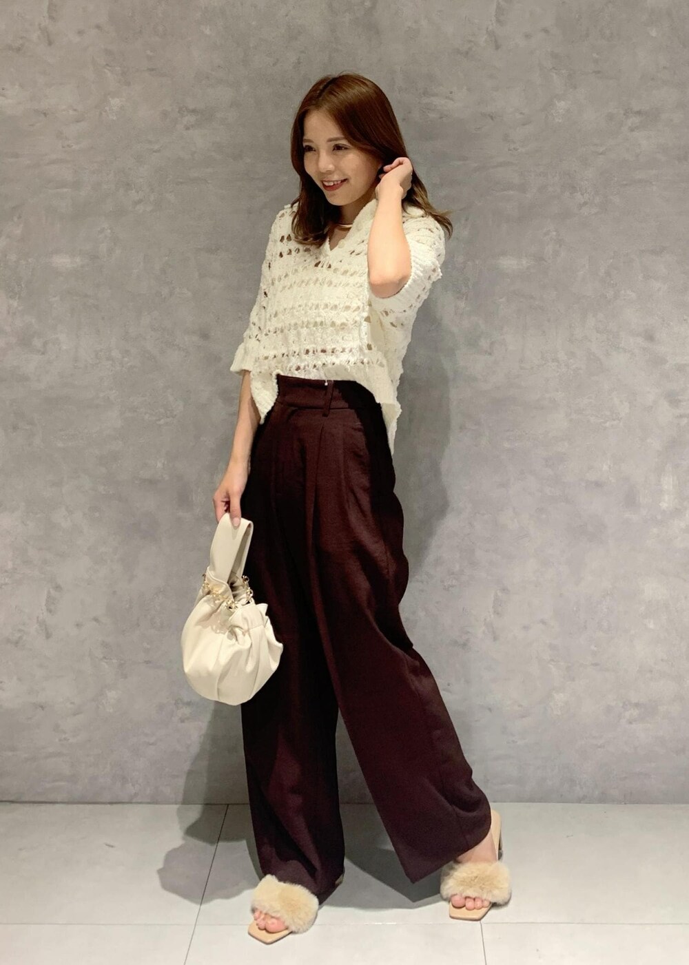 ホワイト系のその他トップス、ブラウン系のスラックス、ホワイト系のハンドバッグを着用したレディースの夏コーディネートの2枚目の写真