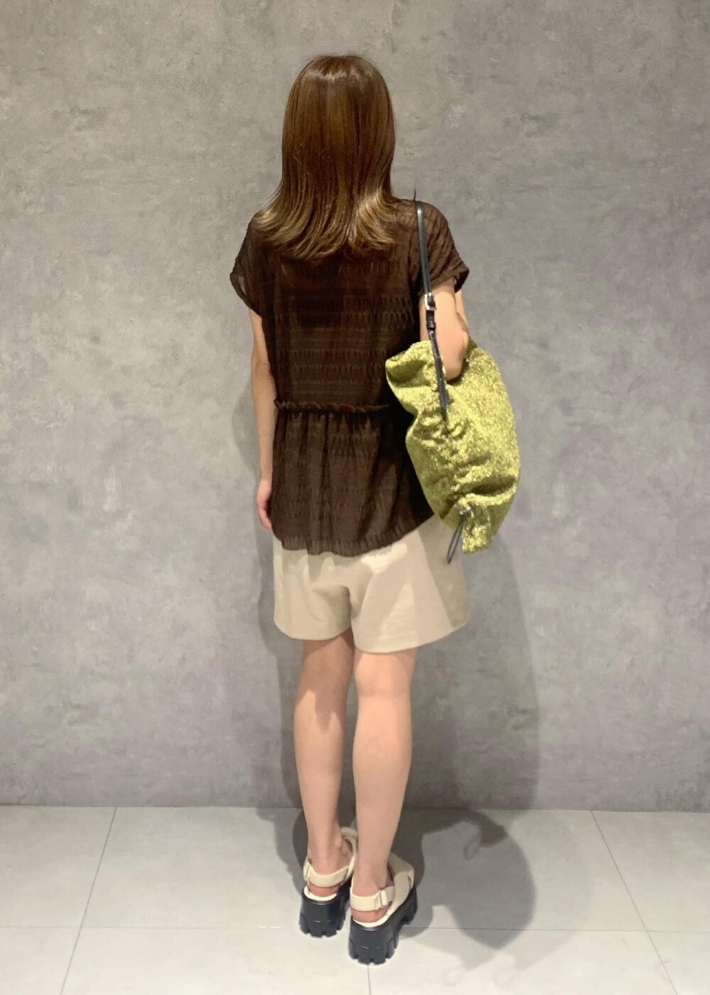 ホワイト系のサンダル、ゴールド系のショルダーバッグ、ブラウン系のTシャツ/カットソーを着用したレディースの夏コーディネートの4枚目の写真