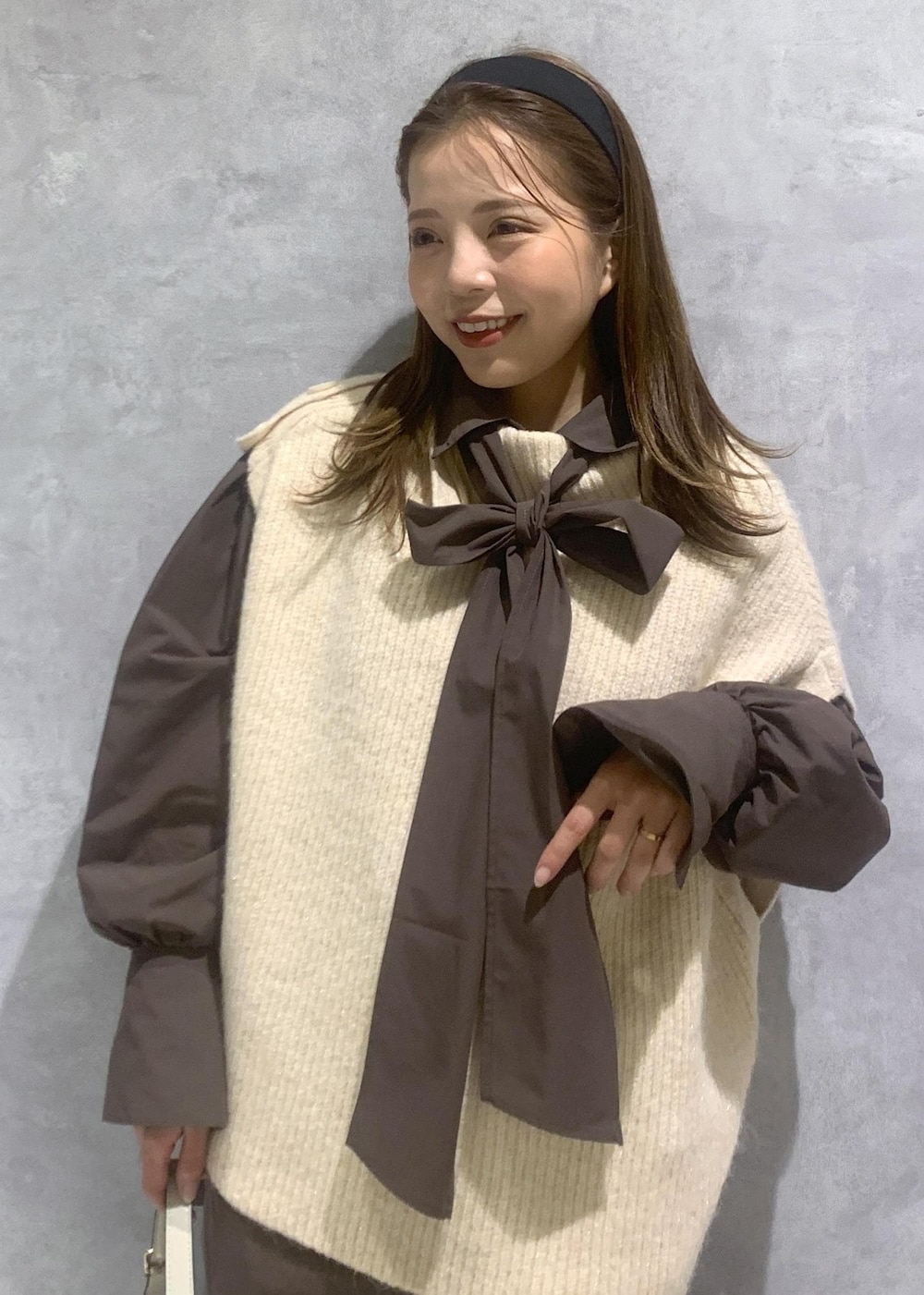 ホワイト系のブーツ、ブラウン系のその他パンツ、ホワイト系のハンドバッグを着用したレディースの秋コーディネートの6枚目の写真