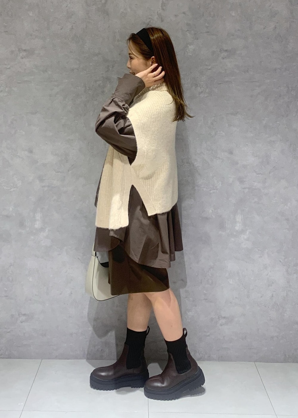 ホワイト系のブーツ、ブラウン系のその他パンツ、ホワイト系のハンドバッグを着用したレディースの秋コーディネートの4枚目の写真