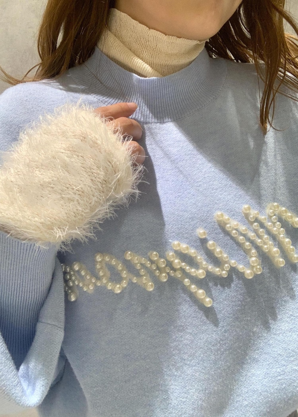 ホワイト系のニット/セーター、ホワイト系のブーツ、ホワイト系のハンドバッグを着用したレディースの冬コーディネートの9枚目の写真