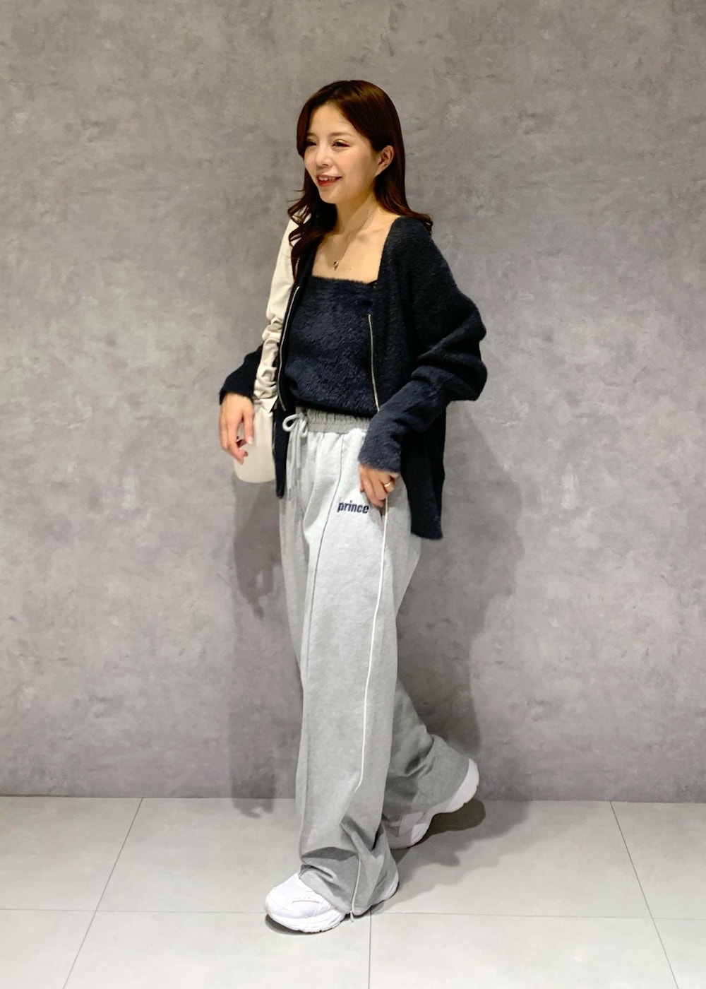 ブラック系のキャミソール、グレー系のその他パンツ、ホワイト系のショルダーバッグを着用したレディースの冬コーディネートの3枚目の写真