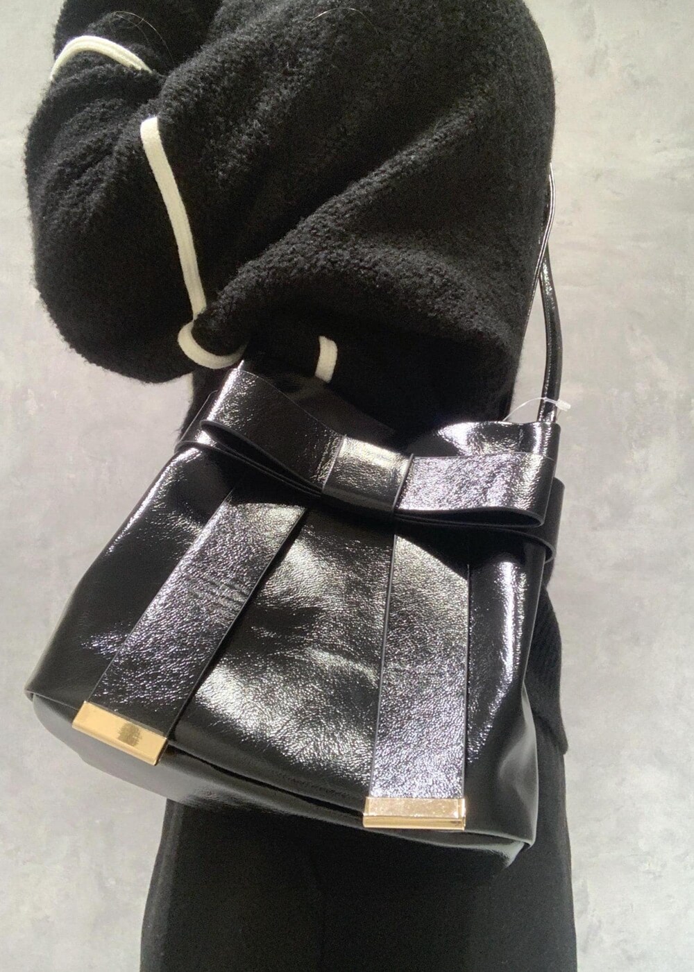 ブラック系のショルダーバッグ、ブラック系のブーツ、ブラック系のニット/セーターを着用したレディースの冬コーディネートの9枚目の写真