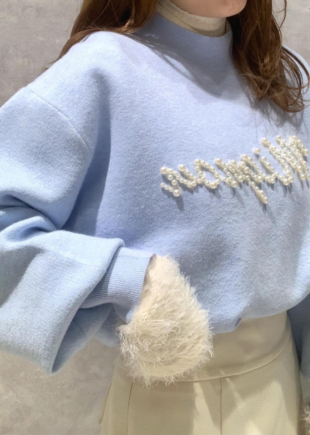 ホワイト系のニット/セーター、ホワイト系のブーツ、ホワイト系のハンドバッグを着用したレディースの冬コーディネートの8枚目の写真