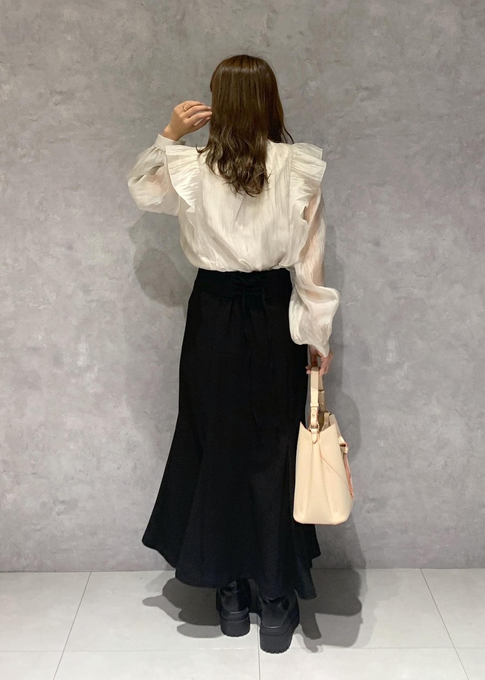 ブラック系のブーツ、ベージュ系のショルダーバッグ、ベージュ系のシャツ/ブラウスを着用したレディースの秋コーディネートの4枚目の写真