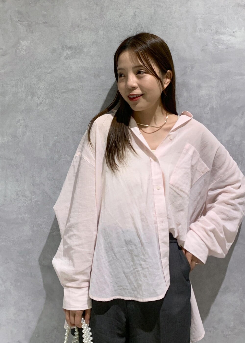 ピンク系のシャツ/ブラウス、グレー系のローファー、ホワイト系のハンドバッグを着用したレディースの春コーディネートの6枚目の写真