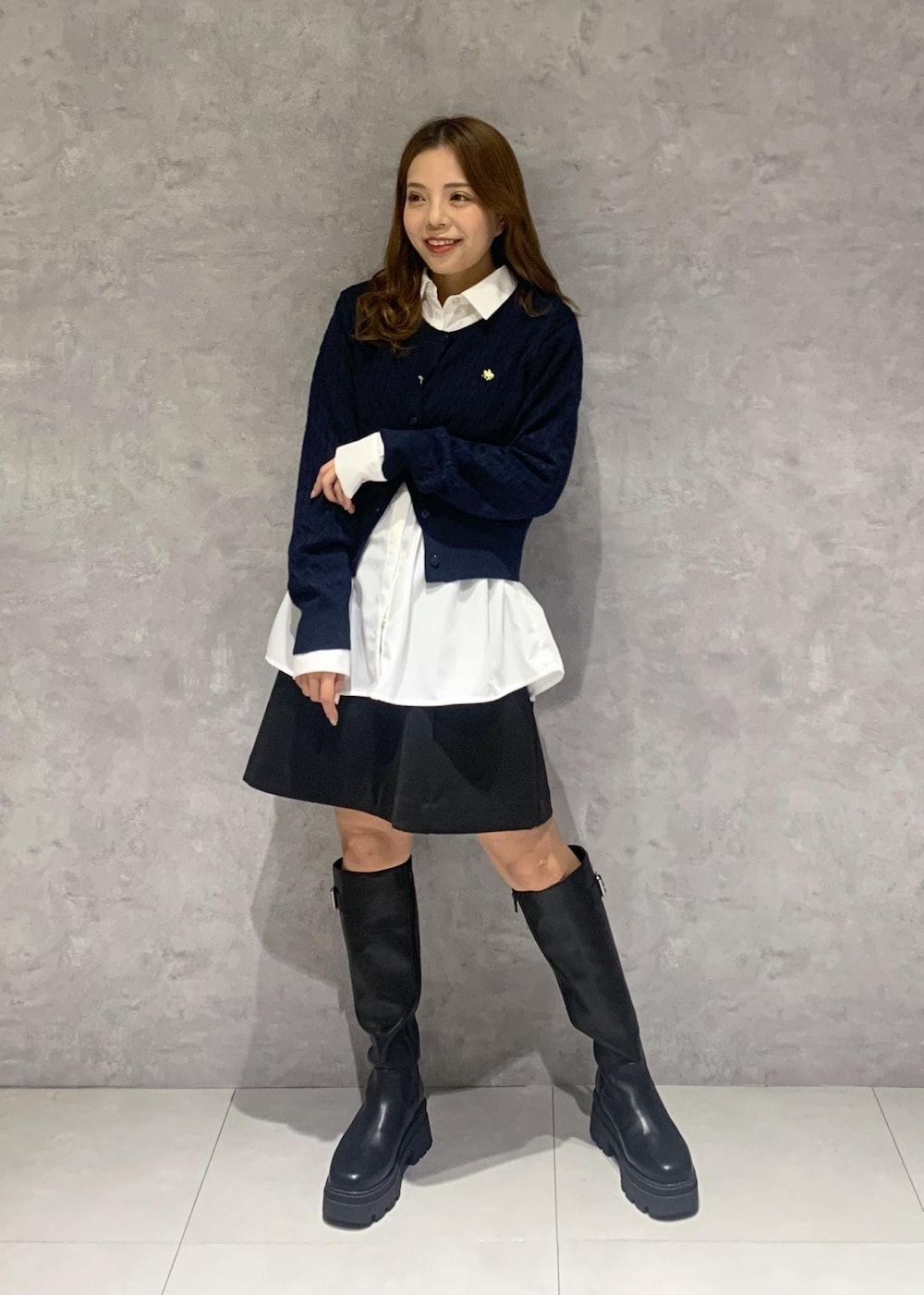 ブラック系のショルダーバッグ、ブラック系のブーツ、グレー系のステンカラーコートを着用したレディースの秋コーディネートの7枚目の写真