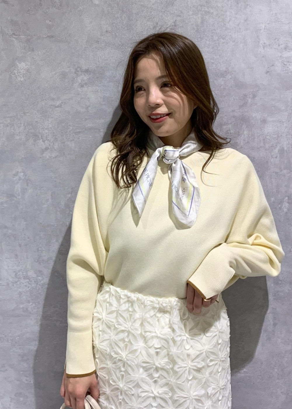 ホワイト系のスカート、ベージュ系のニット/セーター、ホワイト系のローファーを着用したレディースの冬コーディネートの6枚目の写真