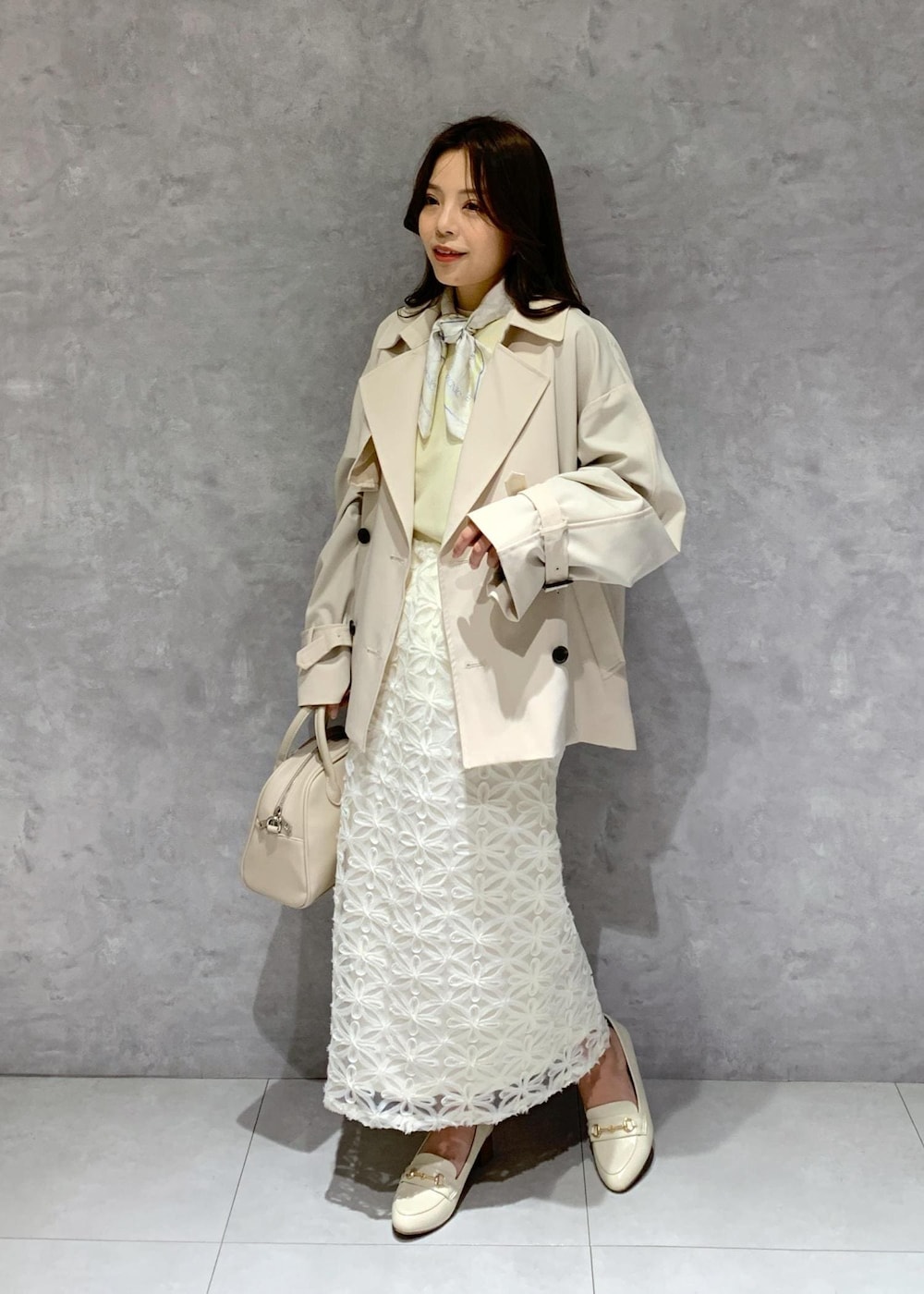 ホワイト系のスカート、ベージュ系のトレンチコート、ベージュ系のニット/セーターを着用したレディースの冬コーディネートの3枚目の写真