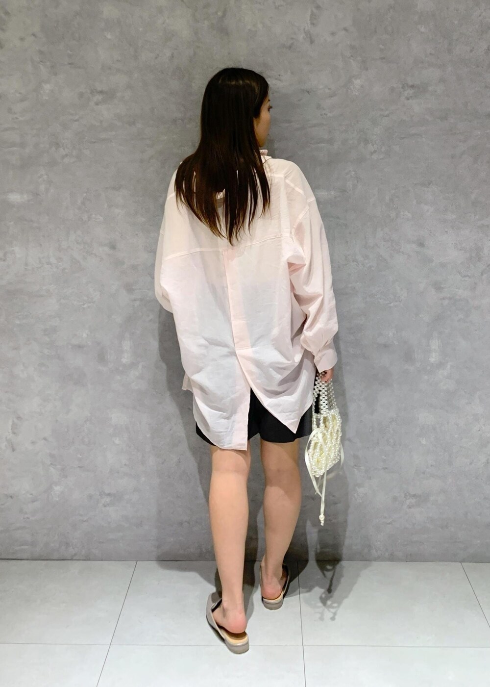 ピンク系のシャツ/ブラウス、グレー系のローファー、ホワイト系のハンドバッグを着用したレディースの春コーディネートの5枚目の写真