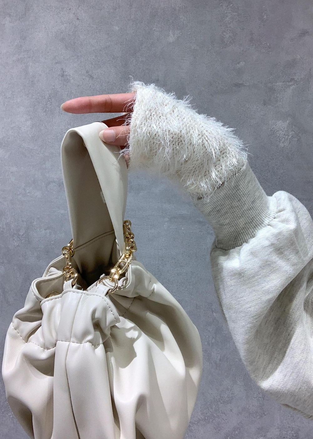 ホワイト系のブーツ、ベージュ系のスカート、ホワイト系のニット/セーターを着用したレディースの秋コーディネートの7枚目の写真