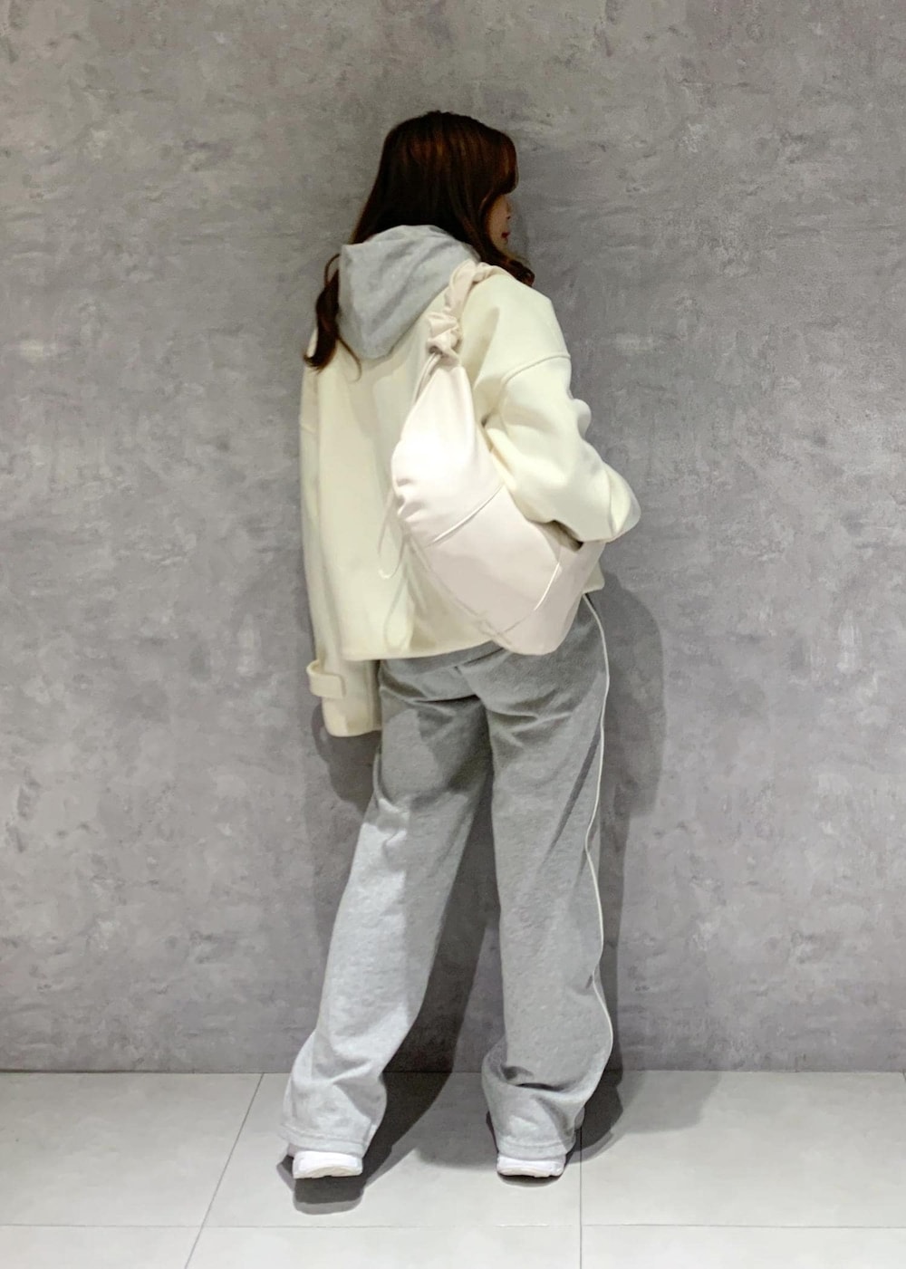 グレー系のその他パンツ、グレー系のパーカー、ホワイト系のショルダーバッグを着用したレディースの冬コーディネートの4枚目の写真
