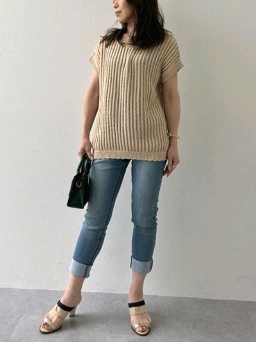 ホワイト系のニット/セーター、ブルー系のデニムパンツを着用したレディースの夏コーディネートの2枚目の写真