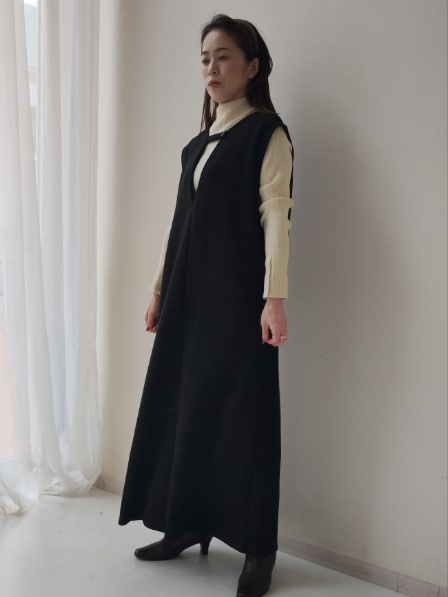 ブラック系のジャンパースカート、ホワイト系のニット/セーターを着用したレディースの秋コーディネートの2枚目の写真