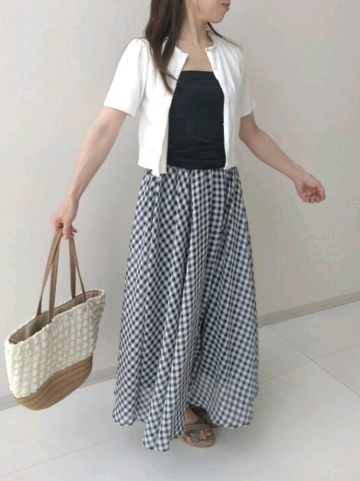 ホワイト系のニット/セーター、ホワイト系のトートバッグ、ブラック系のスカートを着用したレディースの夏コーディネートの2枚目の写真