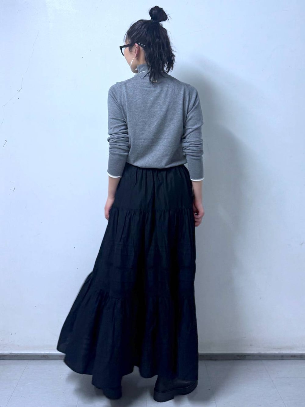 ブラック系のブーツ、ブラック系のハンドバッグ、ブラック系のスカートを着用したレディースの秋コーディネートの7枚目の写真