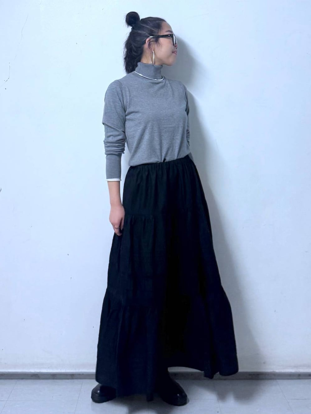 ブラック系のブーツ、ブラック系のハンドバッグ、ブラック系のスカートを着用したレディースの秋コーディネートの5枚目の写真