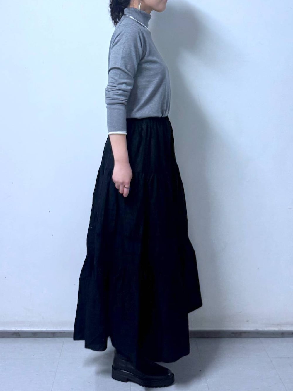 ブラック系のブーツ、ブラック系のハンドバッグ、ブラック系のスカートを着用したレディースの秋コーディネートの6枚目の写真