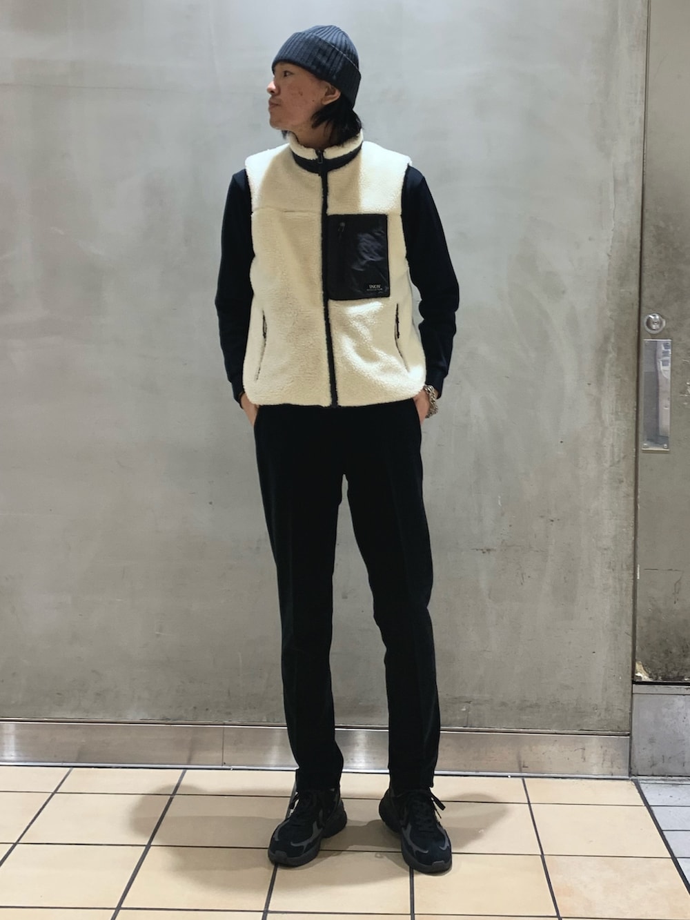 ブルー系のその他パンツ、ホワイト系のダウンベスト、ブルー系のTシャツ/カットソーを着用したメンズの冬コーディネートの4枚目の写真