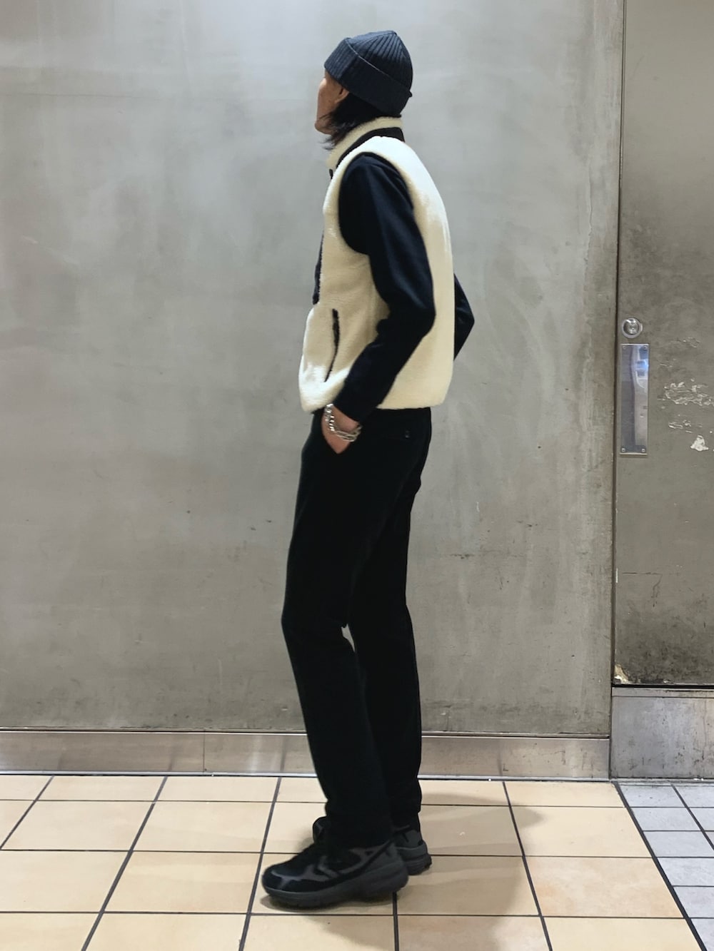 ブルー系のその他パンツ、ホワイト系のダウンベスト、ブルー系のTシャツ/カットソーを着用したメンズの冬コーディネートの2枚目の写真