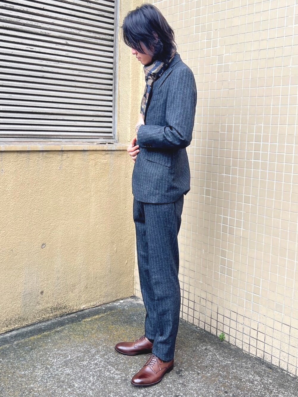 グレー系のスラックス、グレー系のTシャツ/カットソー、グレー系のテーラードジャケットを着用したメンズの冬コーディネートの2枚目の写真