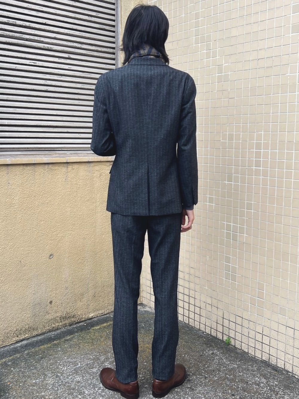 グレー系のスラックス、グレー系のTシャツ/カットソー、グレー系のテーラードジャケットを着用したメンズの冬コーディネートの4枚目の写真