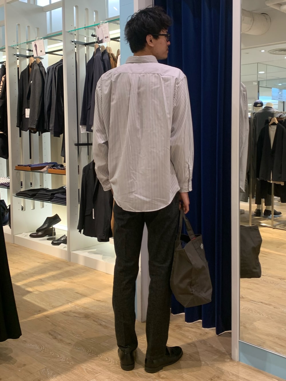 ホワイト系のシャツ/ブラウス、ブラック系のデニムパンツ、グレー系のトートバッグを着用したメンズの秋コーディネートの3枚目の写真