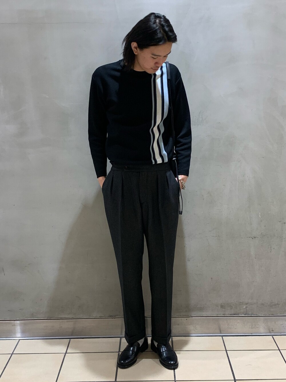 ブラック系のニット/セーター、グレー系のスラックス、ブラック系のショルダーバッグを着用したメンズの冬コーディネートの2枚目の写真