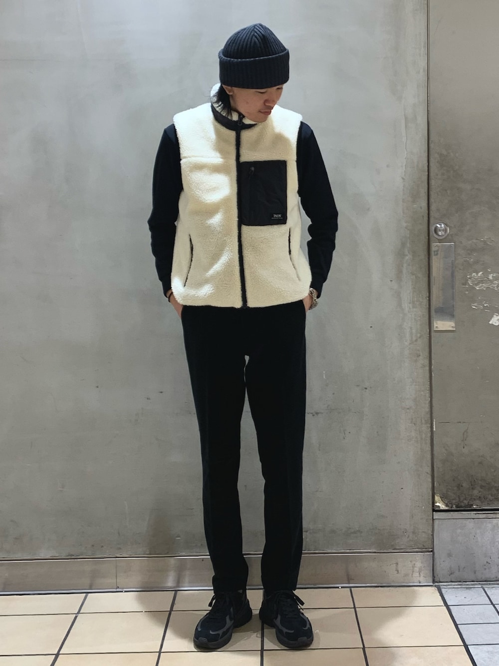 ブルー系のその他パンツ、ホワイト系のダウンベスト、ブルー系のTシャツ/カットソーを着用したメンズの冬コーディネートの5枚目の写真