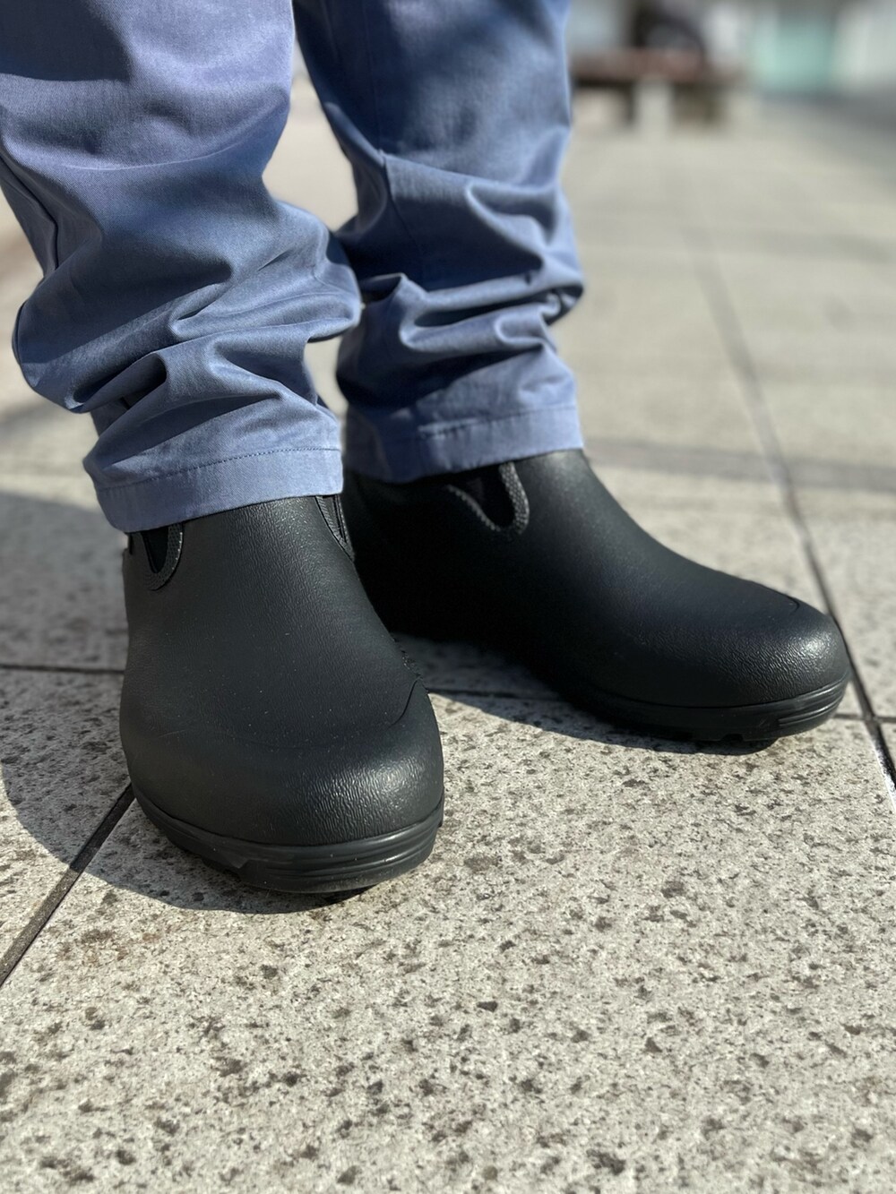 ブラック系のマウンテンパーカー、ブルー系のチノパンツ、グリーン系のショルダーバッグを着用したメンズの冬コーディネートの4枚目の写真