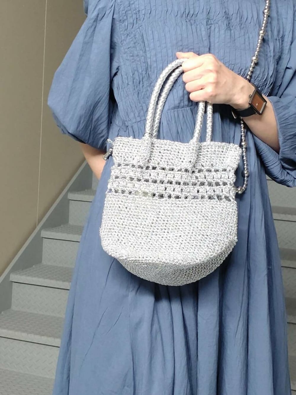 シルバー系のパンプス、シルバー系のショルダーバッグ、ブルー系のワンピースを着用したレディースの春コーディネートの3枚目の写真