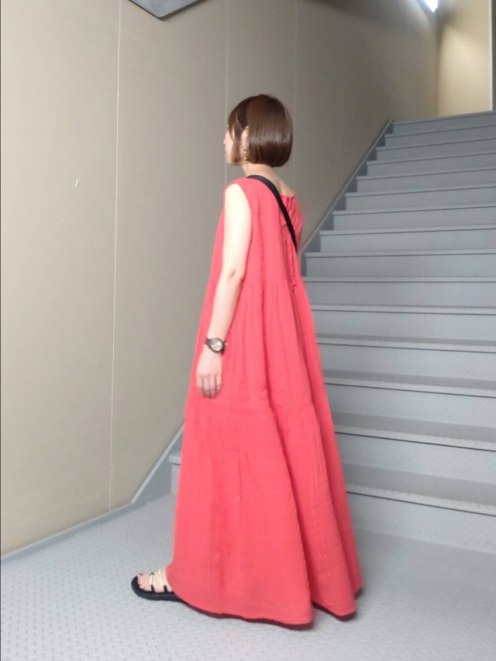 レッド系のワンピース、ブラック系のトートバッグを着用したレディースの夏コーディネートの2枚目の写真