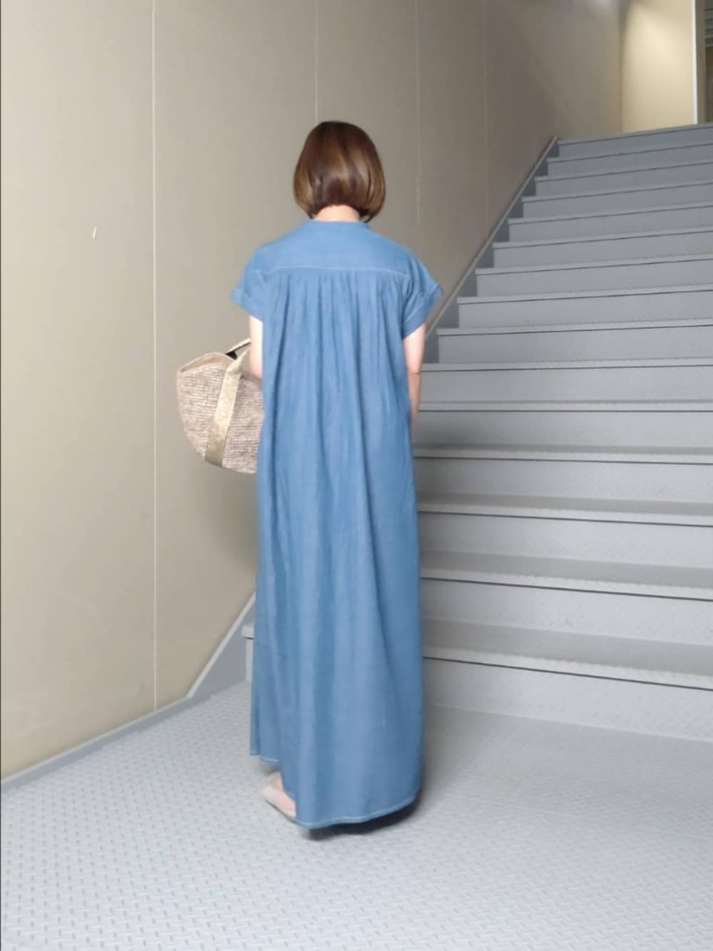 ブルー系のワンピース、ブラウン系のハンドバッグ、その他のバレエシューズを着用したレディースの夏コーディネートの3枚目の写真