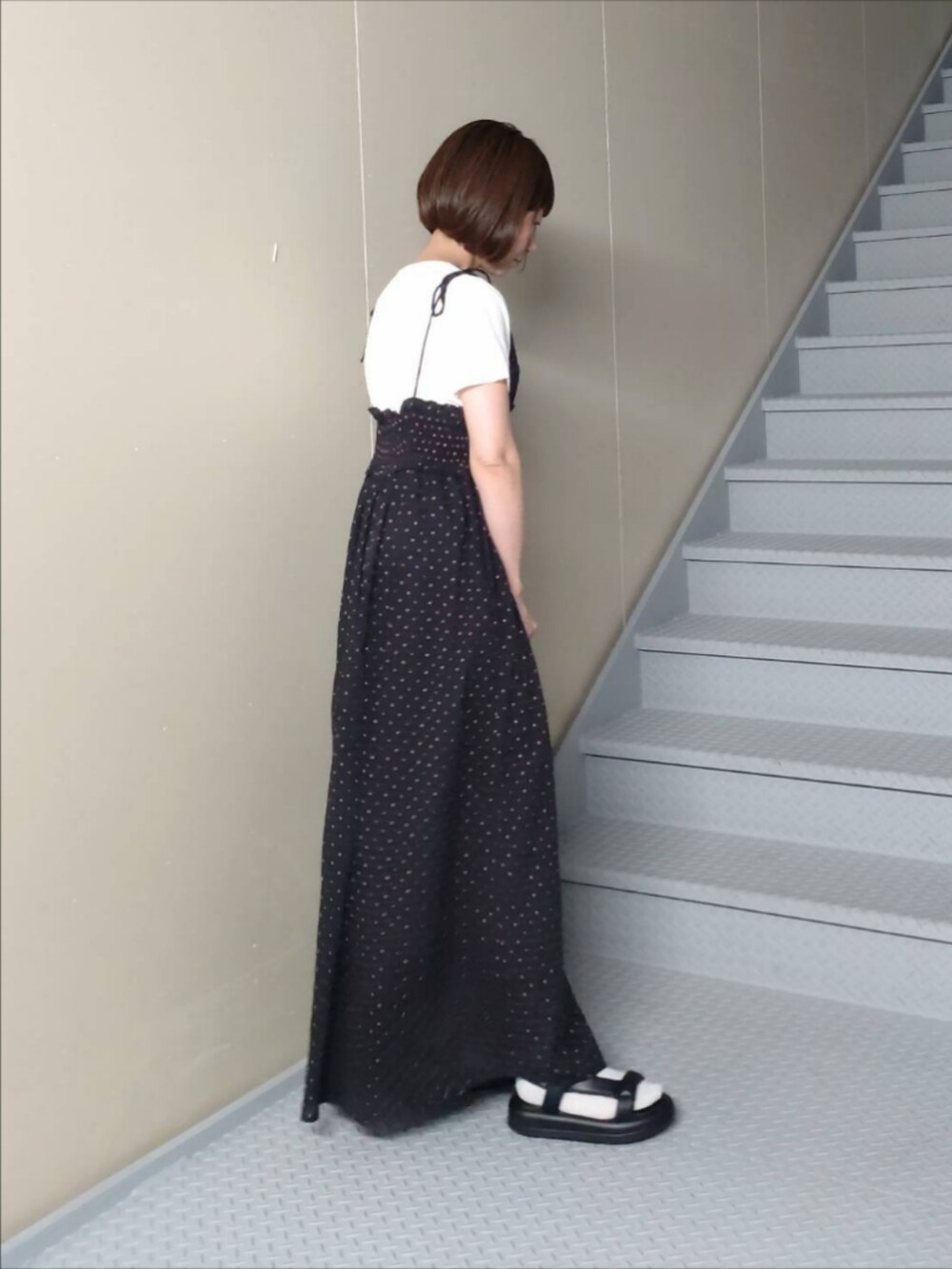 ブラック系のワンピース、ホワイト系のTシャツ/カットソーを着用したレディースの夏コーディネートの2枚目の写真