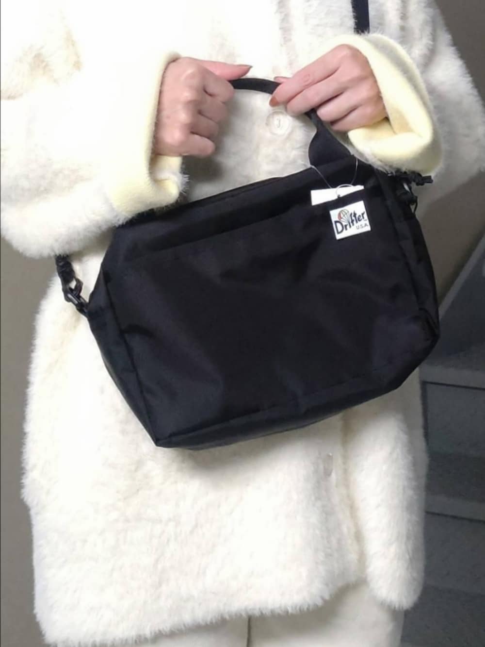 ブラック系のハンドバッグ、ホワイト系のカーディガン/ボレロ、ホワイト系のその他パンツを着用したレディースの秋コーディネートの3枚目の写真