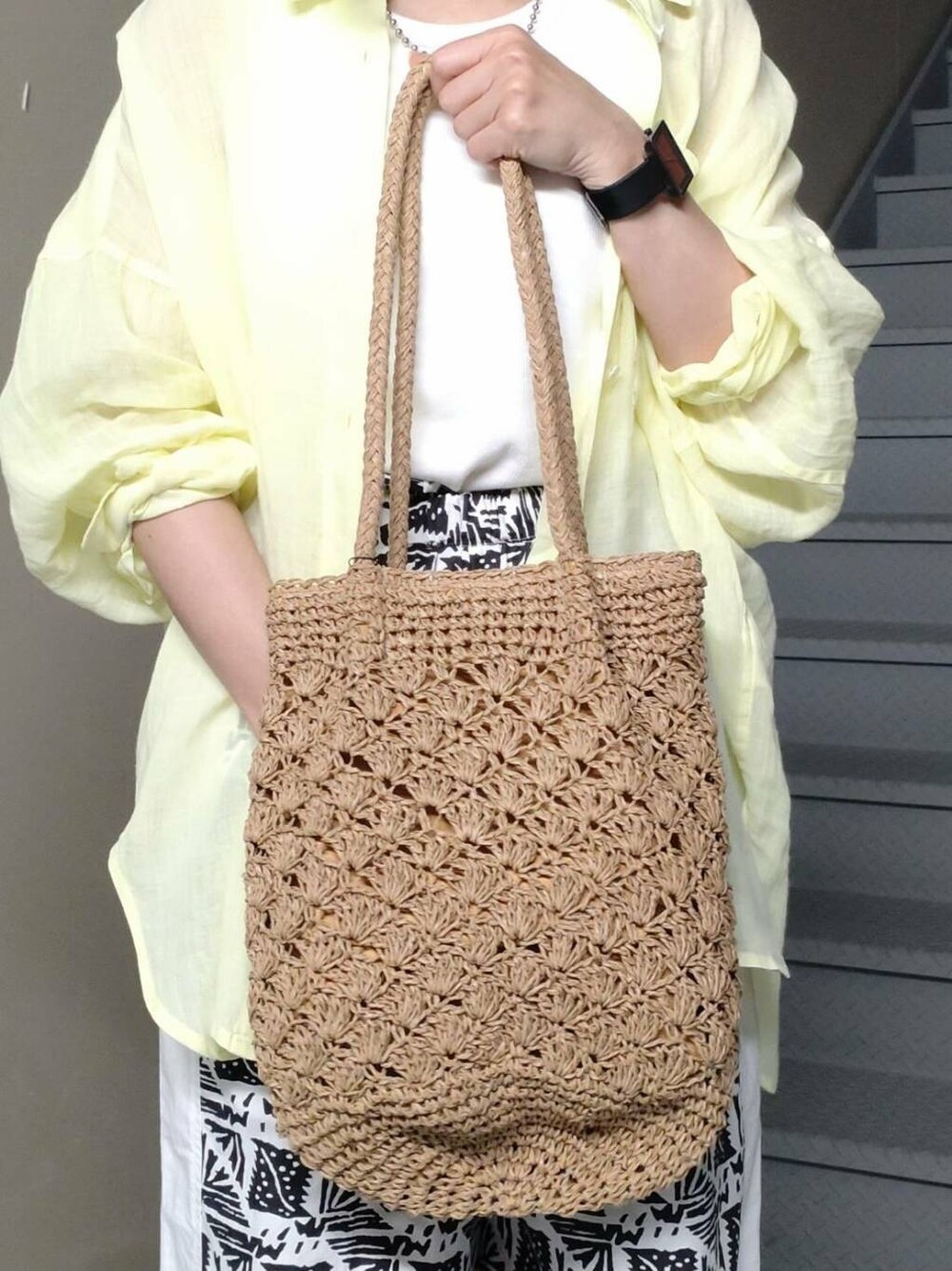 ホワイト系のタンクトップ、ブラック系のサンダル、ベージュ系のトートバッグを着用したレディースの春コーディネートの4枚目の写真