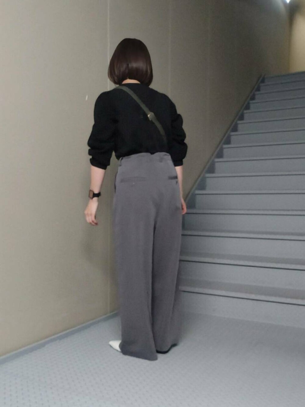 グリーン系のショルダーバッグ、グレー系のその他パンツ、ブラック系のニット/セーターを着用したレディースの冬コーディネートの2枚目の写真