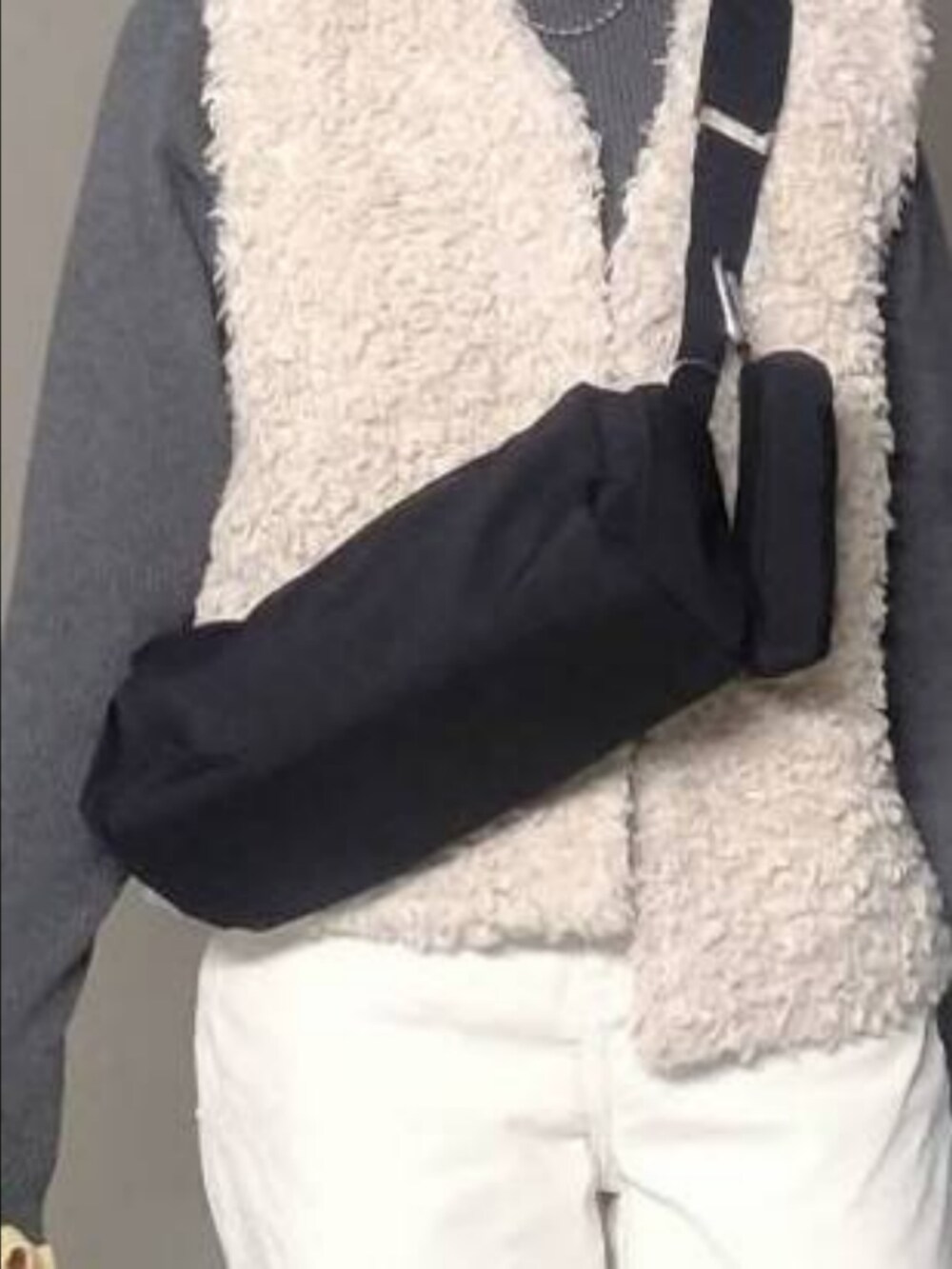 グレー系のニット/セーター、ホワイト系のその他パンツ、ブラック系のショルダーバッグを着用したレディースの秋コーディネートの3枚目の写真