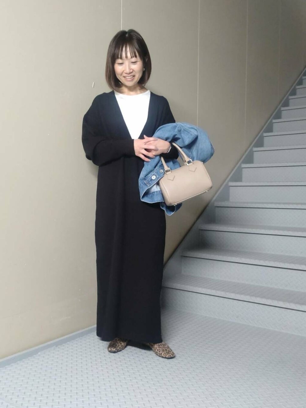 ベージュ系のボストンバッグ、その他のローファー、ブルー系のデニムジャケットを着用したレディースの秋コーディネートの3枚目の写真