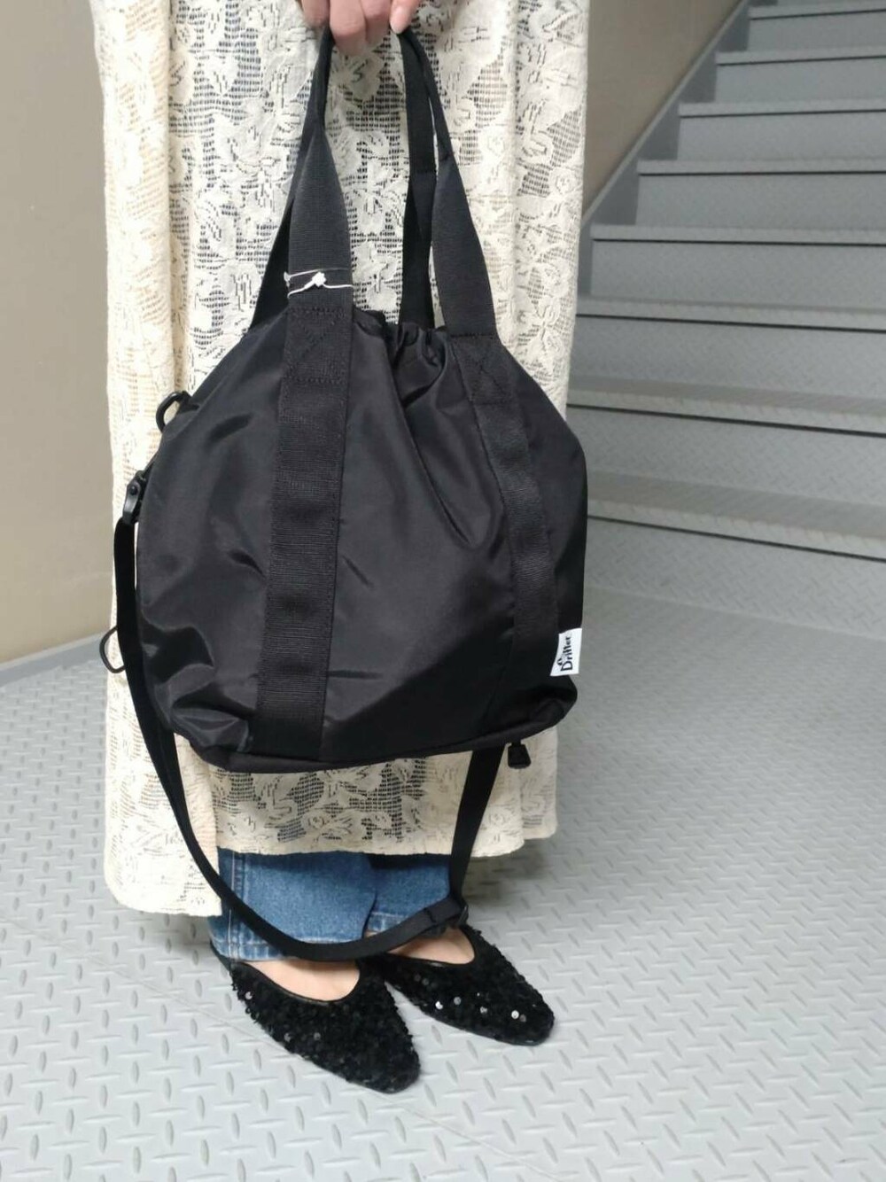 ブラック系のトートバッグ、ホワイト系のタンクトップ、ブラック系のその他シューズを着用したレディースの夏コーディネートの3枚目の写真