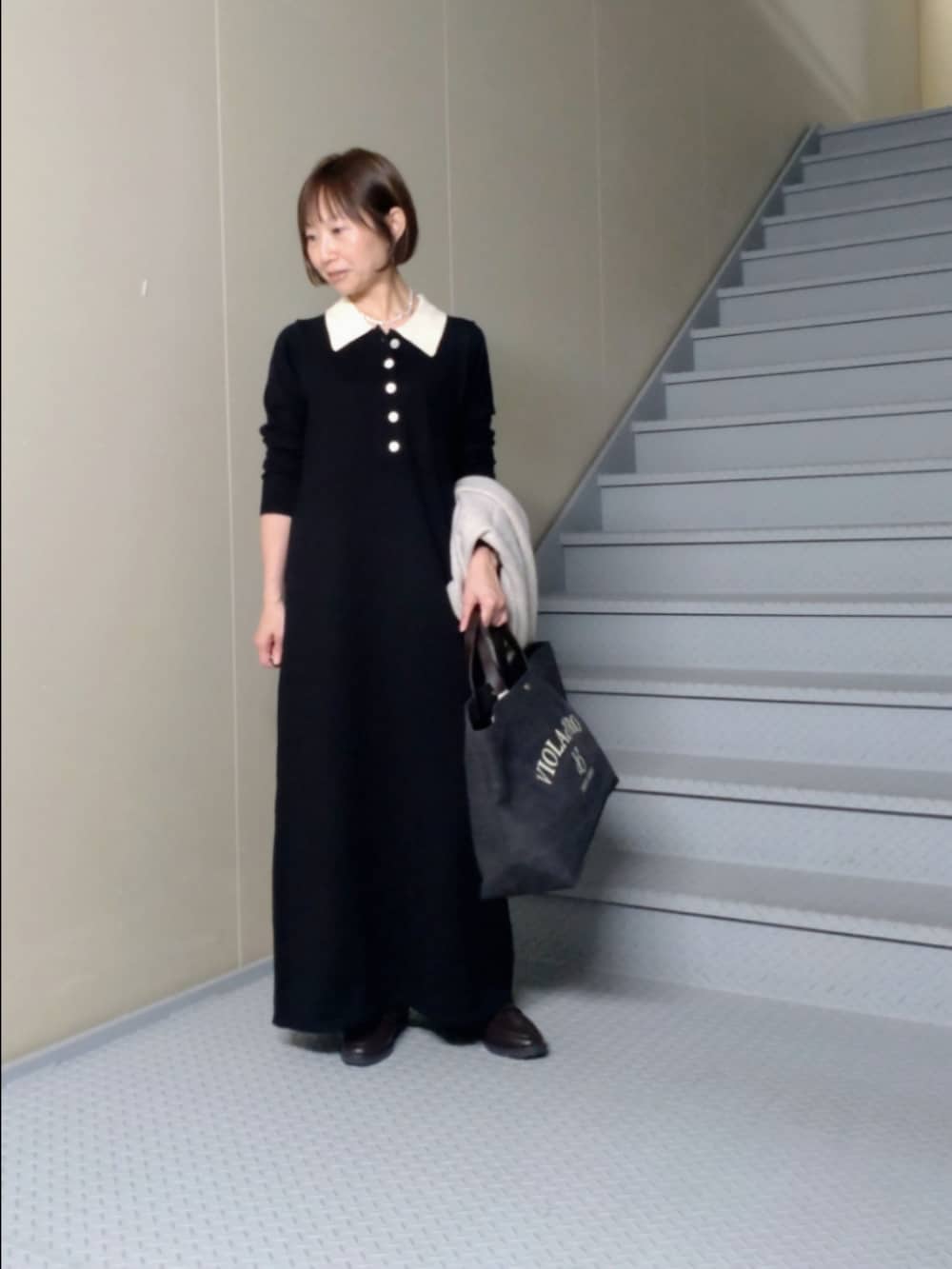 ブラック系のワンピース、ブラウン系のローファーを着用したレディースの秋コーディネートの2枚目の写真