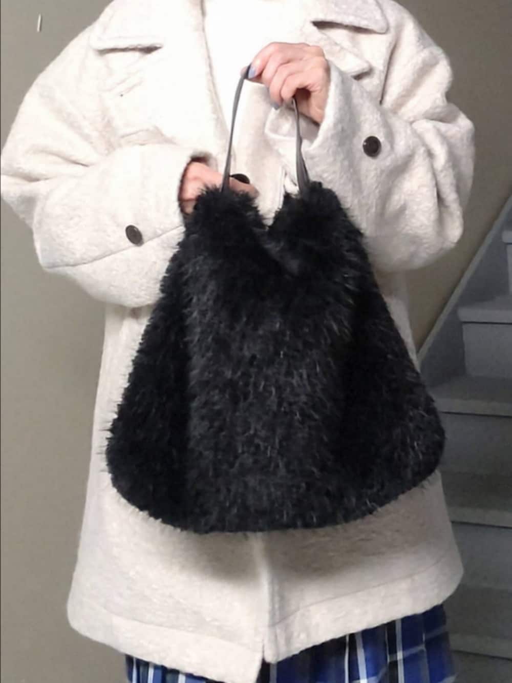 ホワイト系のその他アウター、ブルー系のスカート、ブラック系のハンドバッグを着用したレディースの秋コーディネートの3枚目の写真